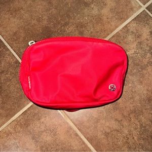 Lululemon red belt bag 1L with white wording/letters in the strap